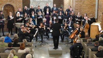 Billede af organist Kevin der dirigere et stort orkester 