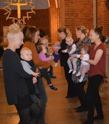 På billedet ses to rækker af forældre med deres babyer