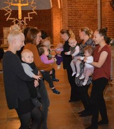 På billedet ses to rækker af forældre med deres babyer