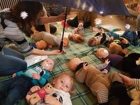 På billedet ses en rundkreds med babyer liggende på kirkens gulv